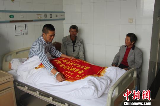 被救的李忠起、張總鳳夫婦看望受傷后的李運飛。 汪渝 攝