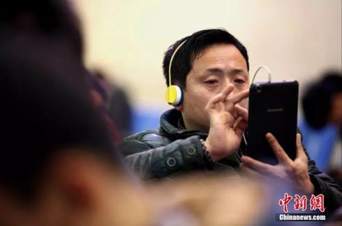 資料圖:候車室內,玩手機的“低頭族”隨處可見。刷微博、聊微信、玩游戲、看電影,高科技將大多旅客變?yōu)槭謾C“低頭族”。<a target='_blank' ><p align=