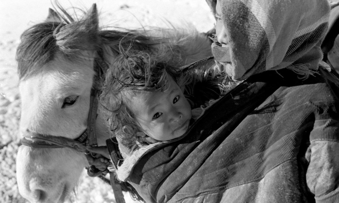 1990年3月，西藏當雄縣納木湖鄉三村女牧民斯卓不畏嚴寒，懷抱幼子，準備到遠處放牧。新華社記者覺果攝