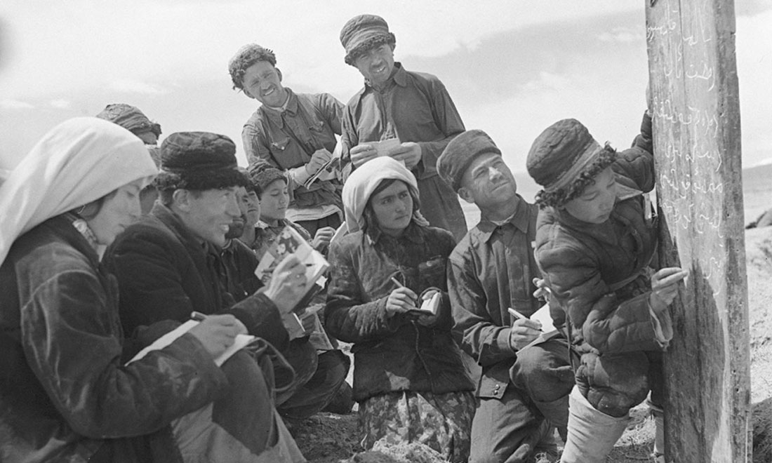 1960年6月，新疆慕士塔格峰下，大人們在小學生幫助下學習文化。新華社記者武純展攝