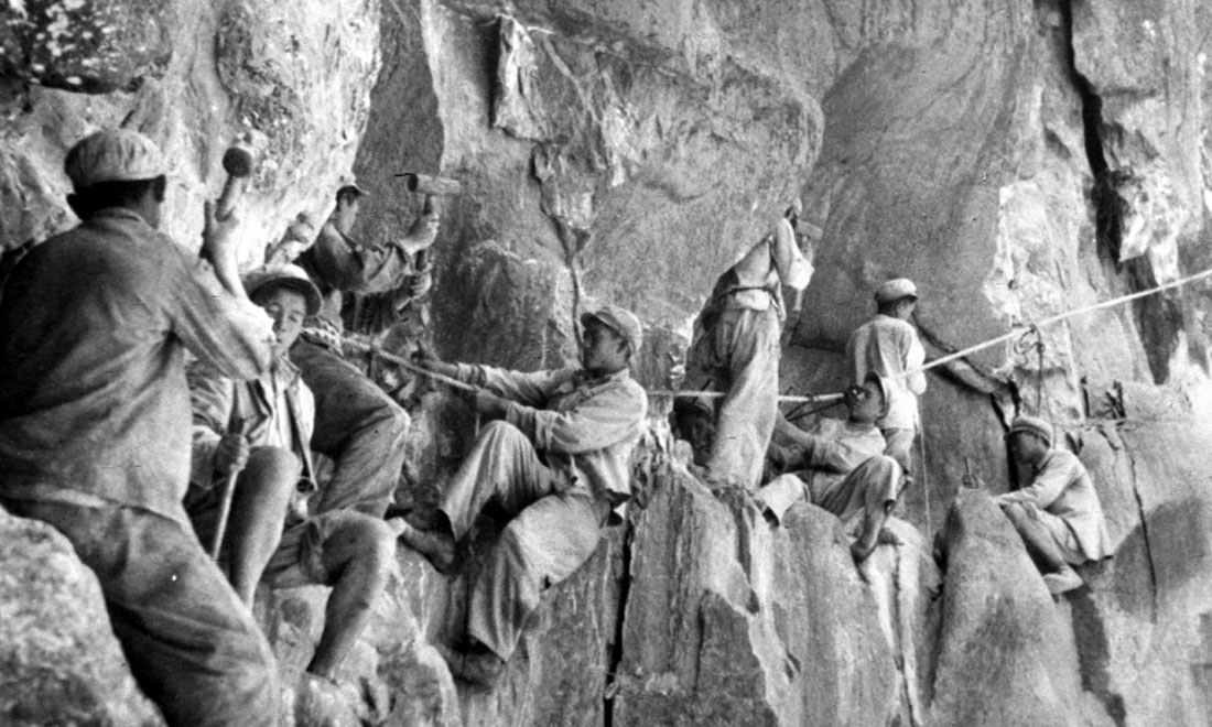 1954年，修筑康藏公路的解放軍戰士們在怒江兩岸的懸崖陡壁上辟山筑路。新華社稿 李萬春、張加里攝