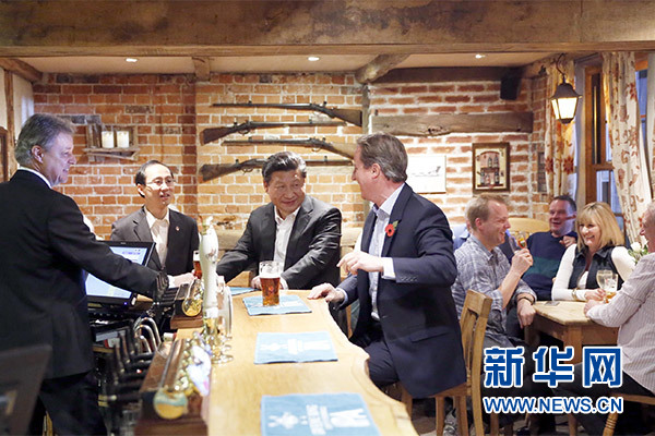 這是會晤結束后，習近平在卡梅倫陪同下乘車前往當?shù)匦℃?zhèn)體驗酒吧文化。新華社記者 鞠鵬 攝